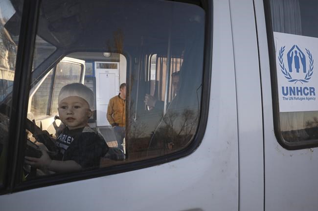 A young child sits behind the wheel of a UNHCR minivan after arriving from Ukraine to Moldova at the Palanca border crossing, Tuesday, April 26, 2022. For the second day in a row, explosions rocked the separatist region of Trans-Dniester in Moldova, knocking out two powerful radio antennas close to the Ukrainian border and further heightening fears of a broader conflict erupting across Europe. (AP Photo/Aurel Obreja)