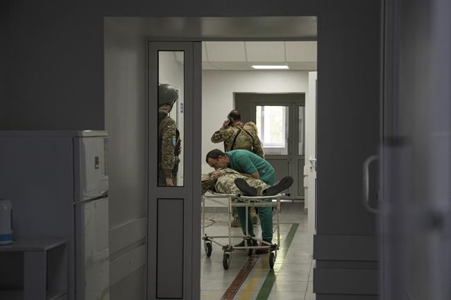 A doctor treats a Ukrainian serviceman injured inside the hospital after an attack by Russian forces in the Donetsk region, Ukraine, on Monday, May 9, 2022.(AP Photo/Evgeniy Maloletka)