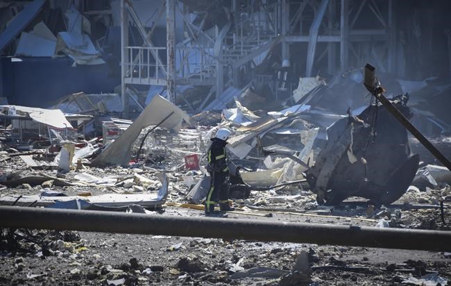 An Ukrainian firefighter works near a destroyed building on the outskirts of Odesa, Ukraine, Tuesday, May 10, 2022. The Ukrainian military said Russian forces fired seven missiles a day earlier from the air at the crucial Black Sea port of Odesa, hitting a shopping center and a warehouse. (AP Photo/Max Pshybyshevsky)