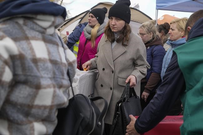 Refugees wait in line after fleeing the war from neighbouring Ukraine at the border crossing in Medyka, southeastern Poland, Friday, April 8, 2022. The federal government has created an online portal for Canadian businesses to donate to Ukrainians who need help to get set up in Canada after fleeing war in their country.THE CANADIAN PRESS/AP/Sergei Grits