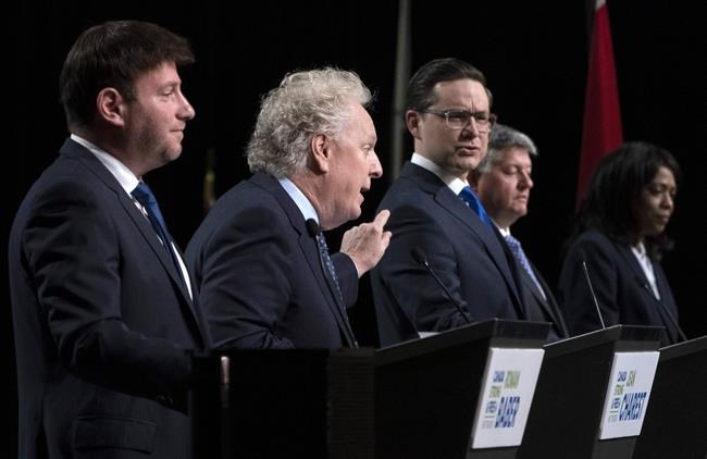 Conservative leadership candidates Jean Charest and Pierre Poilievre spar as Roman Baber, Scott Aitchisonand Leslyn Lewis look on during a debate at the Canada Strong and Free Network conference in Ottawa on Thursday, May 5, 2022. THE CANADIAN PRESS/Adrian Wyld