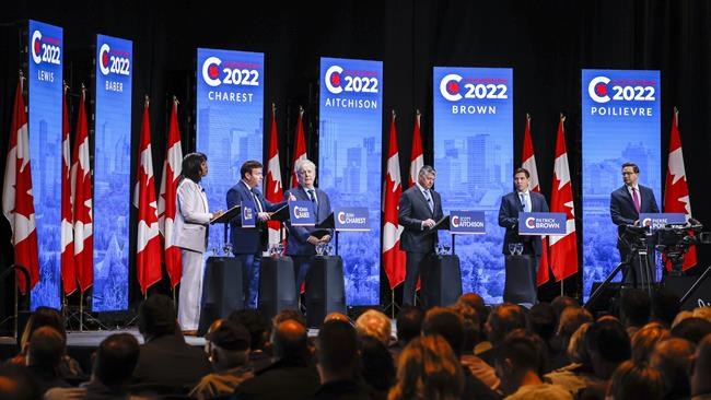 Candidates, left to right, Leslyn Lewis, Roman Baber, Jean Charest, Scott Aitchison, Patrick Brown, and Pierre Poilievre at the Conservative Party of Canada English leadership debate in Edmonton, Alta., Wednesday, May 11, 2022.THE CANADIAN PRESS/Jeff McIntosh