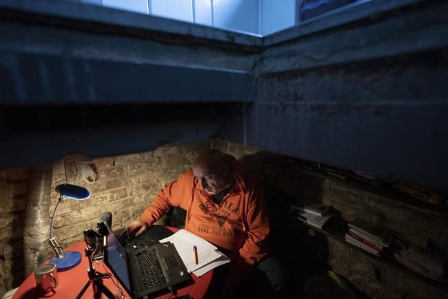 Associate professor of Ukrainian literature Mykhailo Spodarets gives an online lesson from the basement of his house, used as a temporary shelter, in Kharkiv, Ukraine, Thursday, May 12, 2022. (AP Photo/Mstyslav Chernov)