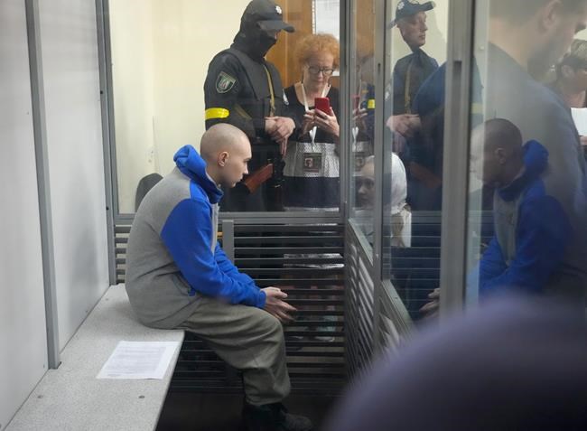 Russian army Sergeant Vadim Shishimarin, 21, is seen behind a glass during a court hearing in Kyiv, Ukraine, Friday, May 13, 2022. The trial of a Russian soldier accused of killing a Ukrainian civilian opened Friday, the first war crimes trial since Moscow's invasion of its neighbor. (AP Photo/Efrem Lukatsky)