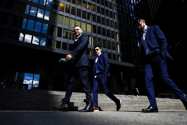 A group of men walk past the Toronto-Dominion Centre on Wellington Street in the financial district in Toronto on Wednesday, September 29, 2021. THE CANADIAN PRESS/Evan Buhler