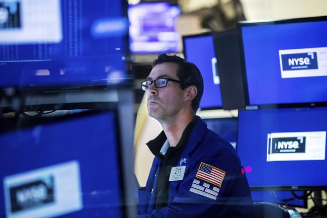 In this photo provided by the New York Stock Exchange, specialist John McNierney works at his post on the floor, Friday, May 27, 2022, in New York. Stocks rose in morning trading on Wall Street Friday, keeping the market on track for its first weekly gain after seven weeks of losses. (Courtney Crow/New York Stock Exchange via AP)