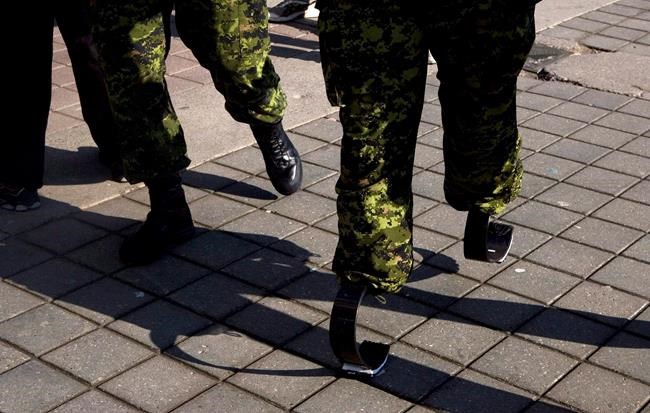 Master Corporal Jody Mitic walks, on his 'running legs' past a fellow soldier, as he prepares for a charity run in Toronto in this March 15, 2009 photo. Canada's auditor general has released a report on wait times for veterans to receive disability benefits. THE CANADIAN PRESS/Chris Young
