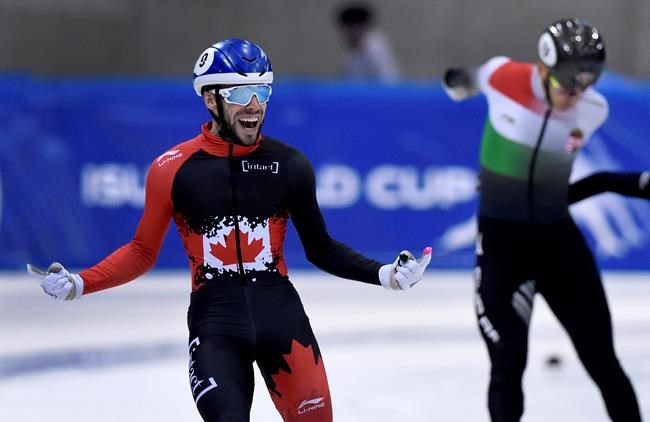 Canada's Steven Dubois celebrates as he crosses the finish line of the men's 500 meters race at the World Cup short track speed skating championship in Dresden, eastern Germany, Sunday, Feb. 9, 2020. (AP Photo/Jens Meyer)