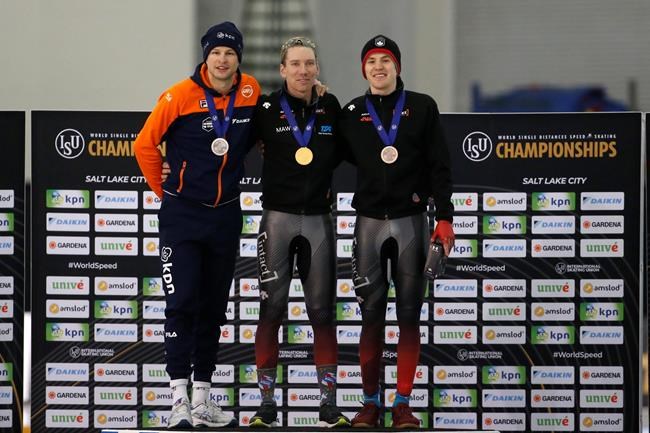 First-place finisher Ted-Jan Bloemen, center, of Canada, shares the podium with second-place Sven Kramer, left, of the Netherlands, and third-place Graeme Fish, right, of Canada, following the men's 5,000 meters at the world single distances speedskating championships Thursday, Feb. 13, 2020, in Kearns, Utah. (AP Photo/Rick Bowmer)