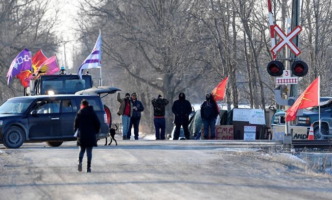 Protesters wave away a member of the media from the rail blockade in Tyendinaga Mohawk Territory, near Belleville, Ont., on Monday Feb. 24, 2020, during a protest in solidarity with Wet'suwet'en Nation hereditary chiefs attempting to halt construction of a natural gas pipeline on their traditional territories. THE CANADIAN PRESS/Adrian Wyld
