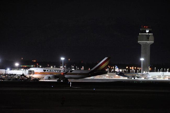 Carrying some 240 American diplomats and citizens, a Boeing 747 aircraft sits on the tarmac of Ted Stevens Anchorage International Airport in Anchorage, Alaska Tuesday, Jan. 28, 2020. Chartered by the U.S. government, the plane flew from Wuhan, China, the source of the recent coronavirus outbreak. The plane will refuel while passengers clear customs and go through the Centers for Disease Control screening before heading to Ontario, California. (AP Photo/Michael Dinneen)