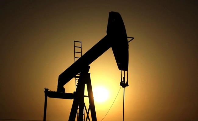 FILE- In this Wednesday, June 8, 2011 file photo, sun sets behind an oil pump in the desert oil fields of Sakhir, Bahrain. The global benchmark for crude oil rose above $70 a barrel on Monday, Jan. 6, 2020 for the first time in over three months, with jitters rising over the escalating military tensions between Iran and the United States. (AP Photo/Hasan Jamali, File)