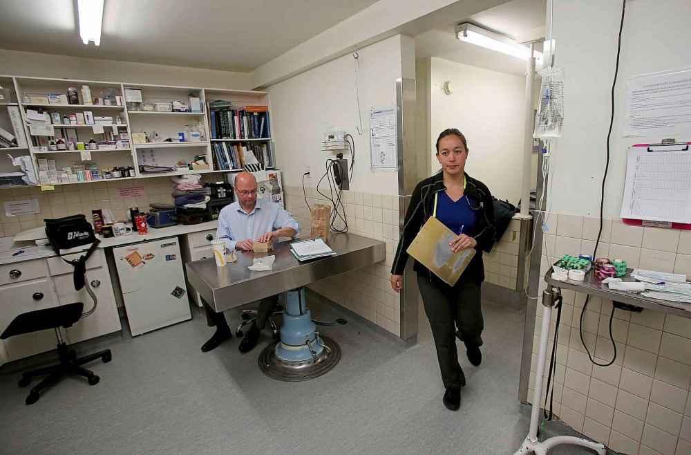 Dr. Chelsea Lim walks through the multipurpose room as Dr. David Scammell takes a quick dinner break.