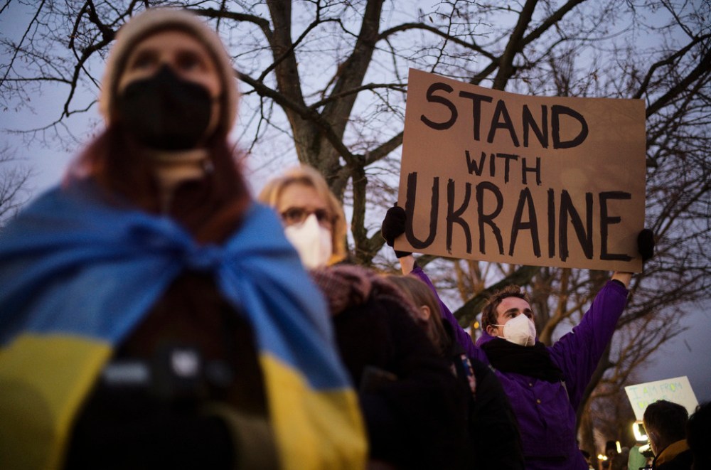 A man holds a poster in support of Ukraine as he attends a demonstration near the Russian embassy to protest against the escalation of the tension between Russia and Ukraine in Berlin, Germany, Tuesday, Feb. 22, 2022. Lawmakers gave Russian President Vladimir Putin permission to use military force outside the country on Tuesday. The move that could presage a broader attack on Ukraine after the U.S. said an invasion was already underway there. (AP Photo/Markus Schreiber)