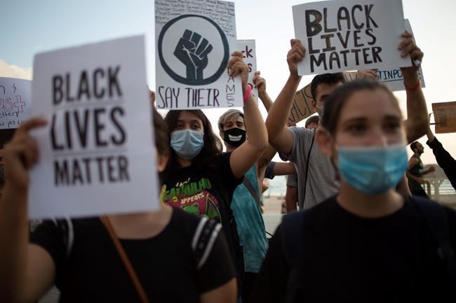 CLARIFIES THAT LOCATION IS THE U.S. EMBASSY BRANCH OFFICE TEL AVIV: Protesters hold signs and shout slogans during a protest to decry the killing of George Floyd in front of the U.S. Embassy Branch Office, in Tel Aviv, Israel, Tuesday, June 2, 2020. (AP Photo/Ariel Schalit)