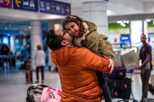 A father and a daughter are reunited as an Air Canada flight with a group of Canadians passengers from Morocco arrive in Montreal on Saturday March 21, 2020. THE CANADIAN PRESS/Andrej Ivanov
