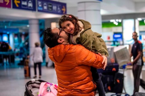 A father and a daughter are reunited as an Air Canada flight with a group of Canadians passengers from Morocco arrive in Montreal on Saturday March 21, 2020. THE CANADIAN PRESS/Andrej Ivanov