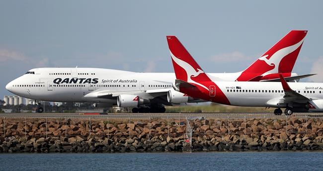 FILE - In this Aug. 20, 2015 file photo, two Qantas planes taxi on the runway at Sydney Airport in Sydney, Australia. Some Asian airlines have rerouted flights to the Middle East to avoid Iranian airspace, amid escalated tensions over the United States’ assassination of a prominent Iranian commander in Iraq. (AP Photo/Rick Rycroft, File)