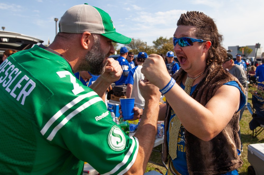 Riders fan Andrew Walker and Bombers fan Neal Einarson pretend to duke it out during the tailgate party prior to kickoff Saturday. (Daniel Crump / Winnipeg Free Press files)