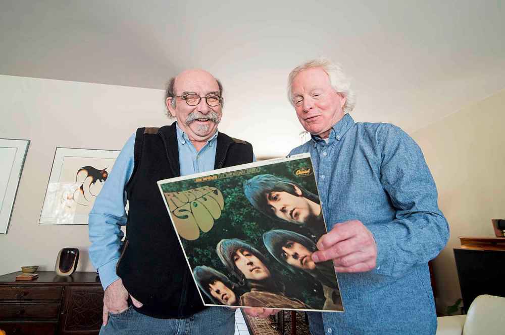 Michael Gillespie (left) and Dan Donahue (right) share a laugh as they look over a copy of Rubber Soul.