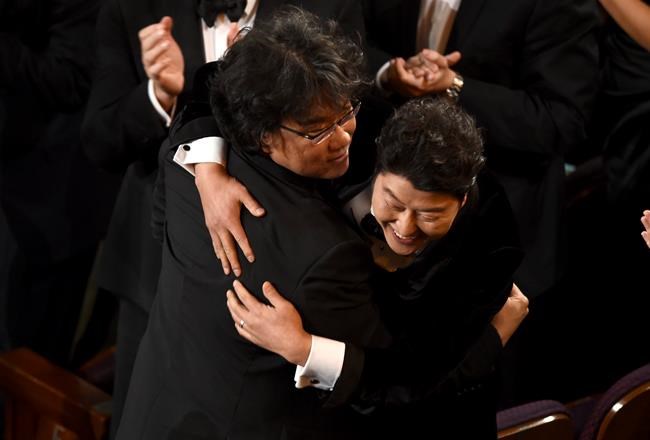 Bong Joon Ho, left, and Kang-Ho Song celebrate before going on stage to accept the award for best picture for
