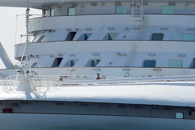 A woman uses excersise equipment on the Grand Princess, a cruise ship carrying multiple people who have tested positive for COVID-19, after docking at the Port of Oakland in Oakland, Calif., Monday, March 9, 2020. (AP Photo/Jeff Chiu)
