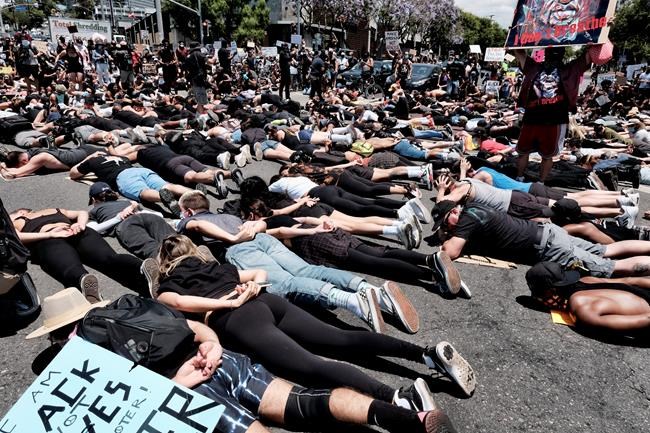 LGBT community members join Black Lives Matter protesters as they block an intersection laying on the street with their hands behind their backs in West Hollywood, Calif. on Wednesday, June 3, 2020, over the death of George Floyd. Floyd, a black man died after being restrained by Minneapolis police officers on May 25. (AP Photo/Richard Vogel)