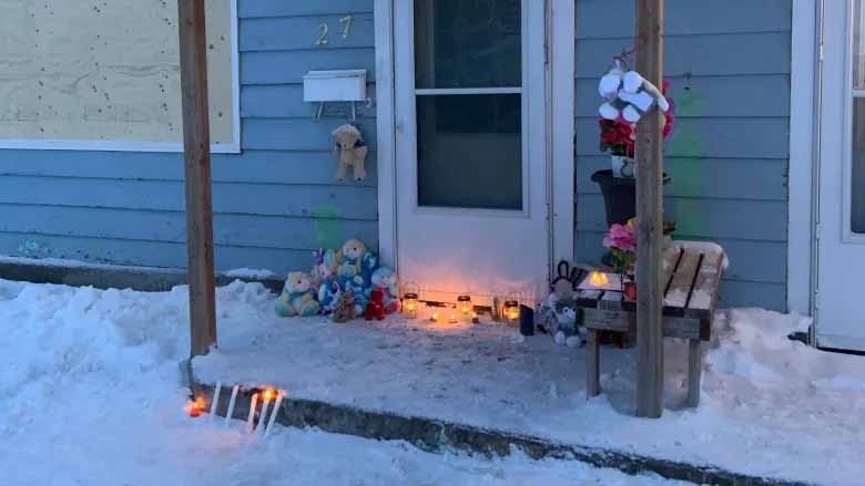 People placed candles, toys and flowers outside of a Portage la Prairie home where the bodies of a mother and two children were found dead a week ago. (CBC / Submitted by Kindra Stothers)
