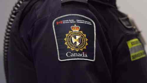CP
A Canadian Border Services agent stands watch at Pearson International Airport in Toronto on Tuesday, December 8, 2015. A group of doctors, lawyers, legal scholars and human rights organizations is calling on the federal government to halt the rollout of a new policy that will see border officers outfitted in defensive gear when dealing with refugees in detention. THE CANADIAN PRESS/Darren Calabrese
