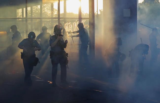 Police move through an area during demonstrations Thursday, May 28, 2020, in St. Paul, Minn. Protests over the death of George Floyd, the black man who died in police custody broke out in Minneapolis for a third straight night. (AP Photo/Julio Cortez)