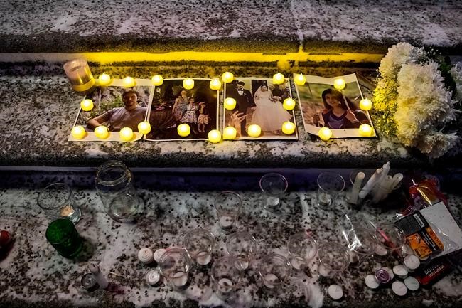 Mourners place candles and photographs during a vigil for those who were among the 176 people who were killed when Ukraine International Airlines Flight PS752 crashed after takeoff near Tehran, Iran, outside the Alberta Legislature Building in Edmonton on Wednesday, Jan. 8, 2020. THE CANADIAN PRESS/Codie McLachlan