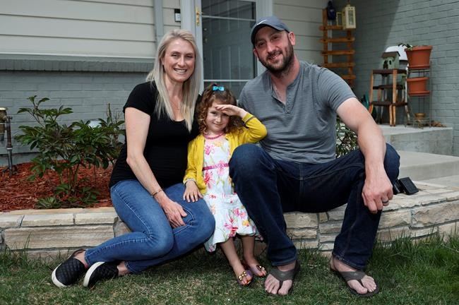 Eli Oderberg, right, sits with Katie Evers and their 4-year-old daughter, Everlee, outside their home in southeast Denver on Thursday, April 30, 2020. Oderberg, like 30 million people around the United States who have filed for unemployment benefits after losing their jobs during the coronavirus pandemic, is facing the specter of paying the monthly rent with the flip of the calendar. (AP Photo/David Zalubowski)