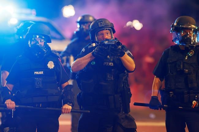 Denver police fire canisters to disperse a protest outside the State Capitol over the death of George Floyd, a handcuffed black man in police custody in Minneapolis, Thursday, May 28, 2020, in Denver. (AP Photo/David Zalubowski)