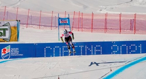 FILE - In this Jan. 20, 2019 file photo, Liechtenstein's Tina Weirather speeds down the course as a banner advertising the ski world championships in Cortina d'Ampezzo is seen in background, during an alpine ski, women's World Cup super-G in Cortina D'Ampezzo, Italy. The natural beauty of Cortina will be of special importance at the alpine ski World championships, with organizers hoping that the images from the slopes beamed around the globe to TV viewers will make up for the lack of fans amid the coronavirus pandemic. (AP Photo/Giovanni Auletta, File)