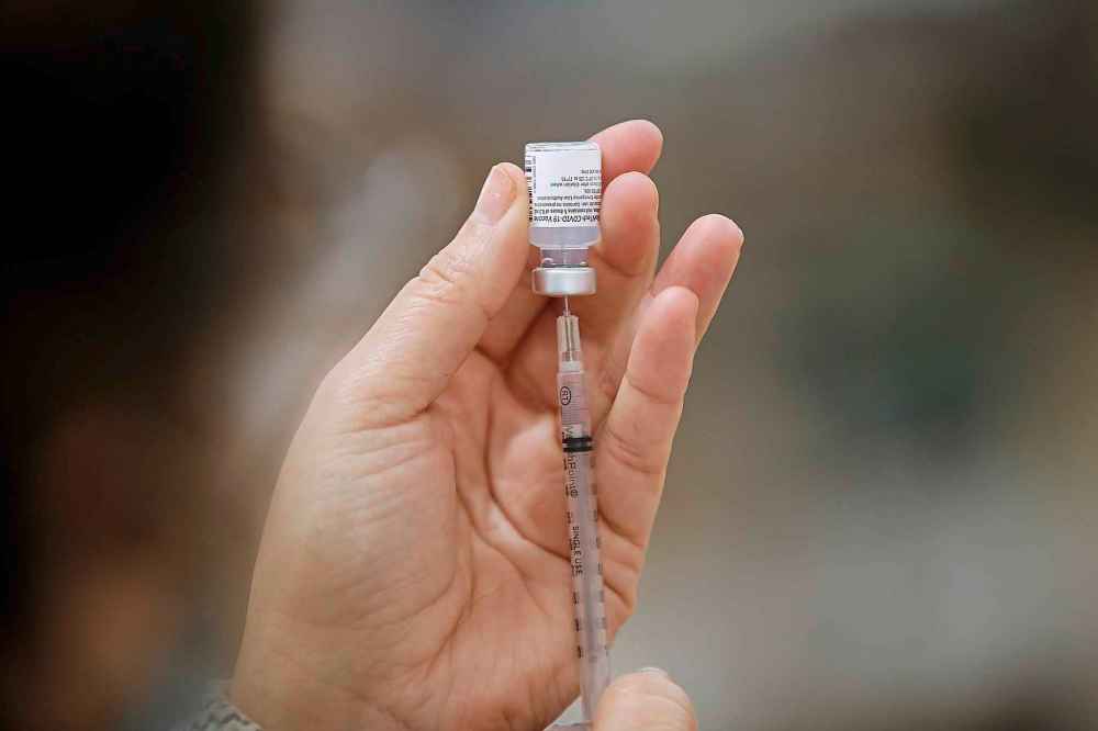 LoriAnn Laramee, public health nurse, draws up COVID-19 vaccine into syringes in the COVID-19 vaccination clinic at the Health Sciences Centre in Winnipeg, Wednesday, December 16, 2020. THE CANADIAN PRESS/John Woods