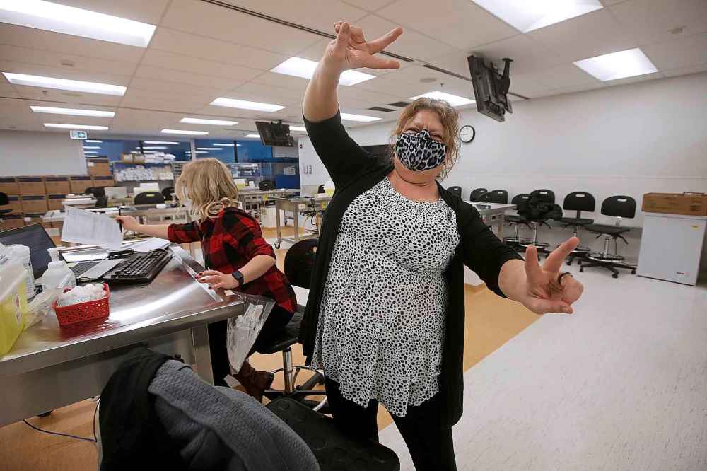 Sherry Plett, registered nurse, Southern Health – Santé Sud, celebrates after receiving the second in Manitoba and her first COVID-19 inoculation from Danielle Kim, public health nurse, in the COVID-19 vaccination clinic at the Health Sciences Centre in Winnipeg, Wednesday, December 16, 2020. THE CANADIAN PRESS/John Woods