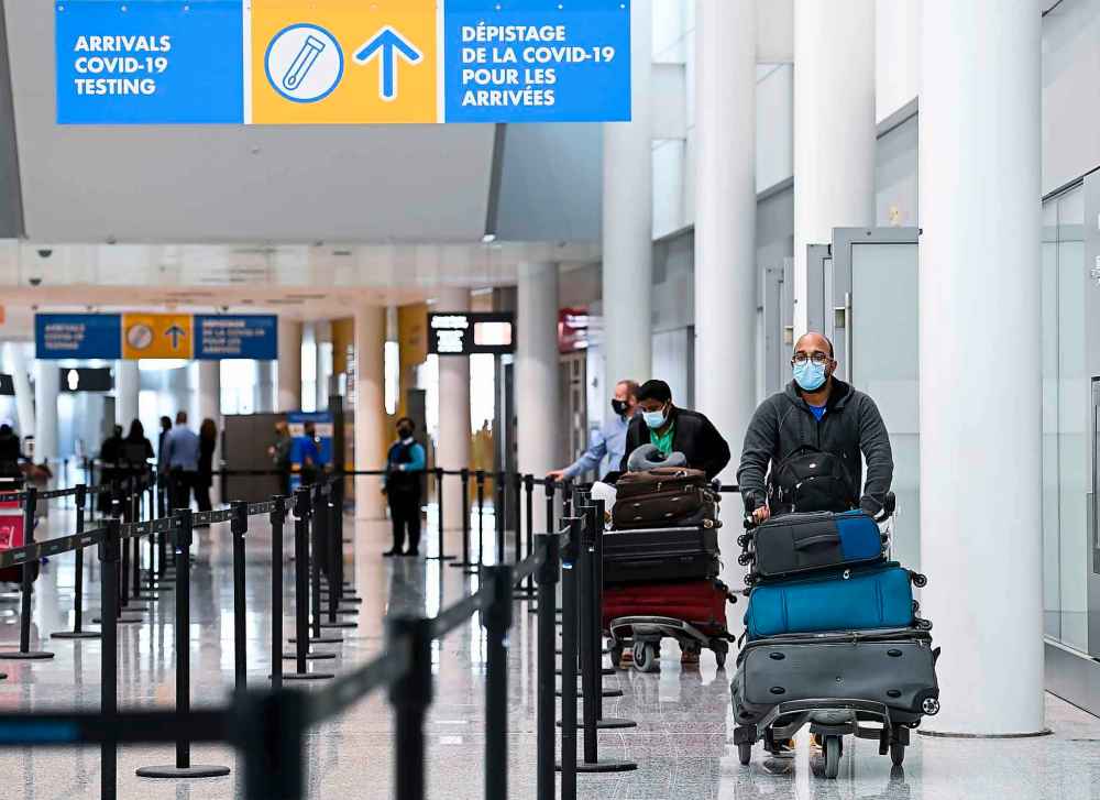Travellers are directed to take a COVID-19 test after arriving on a international flight at Pearson International Airport. The core federal public service, air travel and rail employees and travellers must all be fully vaccinated against COVID-19 by the end of October, according to Canada’s new mandatory vaccine policy. For travellers, there will be a short transition period to allow the unvaccinated to show a negative molecular COVID-19 test instead, though the grace period will last only until Nov. 30. THE CANADIAN PRESS FILES/Nathan Denette