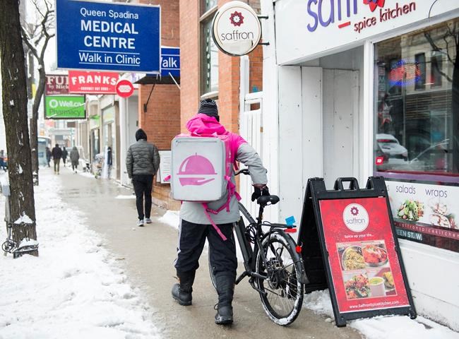 A Foodora courier is pictured as they pick up an order for delivery from a restaurant in Toronto, Thursday, Feb. 27, 2020. THE CANADIAN PRESS/Nathan Denette