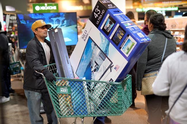 Black Friday shoppers wait in line to check out at the Nebraska Furniture Mart store in Omaha, Neb., Friday, Nov. 23, 2018. Canadian shoppers craving a deal increasingly turn to Black Friday — a sales bonanza imported from America, where retailers long slashed prices the day after their Thanksgiving holiday — at the expense of another sales spree, Boxing Day. THE CANADIAN PRESS/AP-Nati Harnik