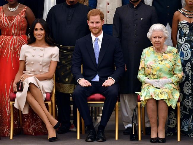 Britain's Queen Elizabeth, Prince Harry and Meghan, Duchess of Sussex pose for a group photo at the Queen's Young Leaders Awards Ceremony at Buckingham Palace in London on Tuesday, June 26, 2018. A journalism expert says Prince Harry and Meghan may have been drawn to Canada's