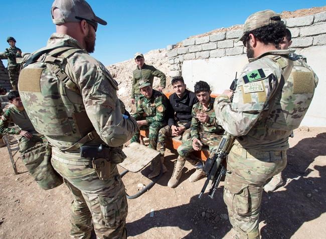 In this Feb. 20, 2017 file photo, Canadian special forces soldiers, left and right, speak with Kurdish Peshmerga fighters at an observation post, in northern Iraq. Federal opposition parties are divided over whether Canada should press ahead with its five-year-old mission in Iraq or start bringing home its soldiers, some of whom were forced to take cover last week from Iranian ballistic missiles. THE CANADIAN PRESS/Ryan Remiorz