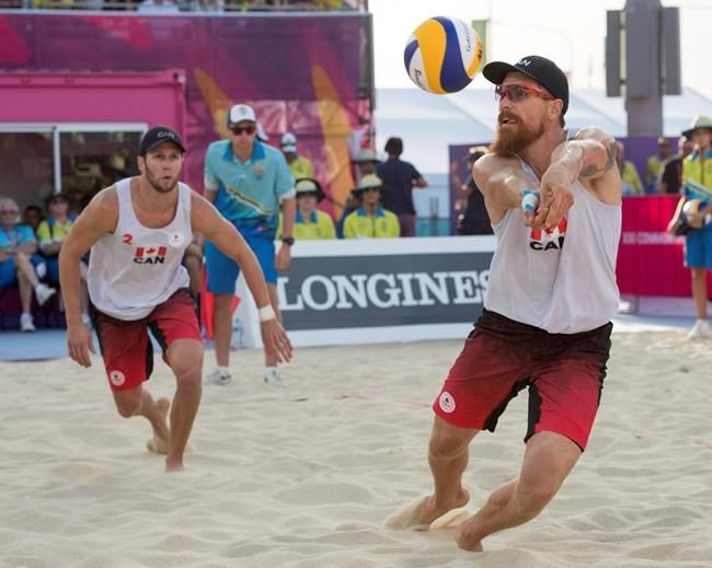Canada's Samuel Pedlow, right, returns a shot as teammate Sam Schachter looks on during the beach volleyball final against Australia at the Commonwealth Games Thursday, April 12, 2018 in Gold Coast, Australia. THE CANADIAN PRESS/Ryan Remiorz
