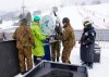 Japan Self-Defense Forces members and event staff put away a clock after it was announced that the men's slalom race has been cancelled due to weather conditions during the FIS Alpine Ski World Cup at Naeba Ski Resort in Yuzawa, Niigata prefecture, northern Japan, Sunday, Feb. 23, 2020. (AP Photo/Christopher Jue)