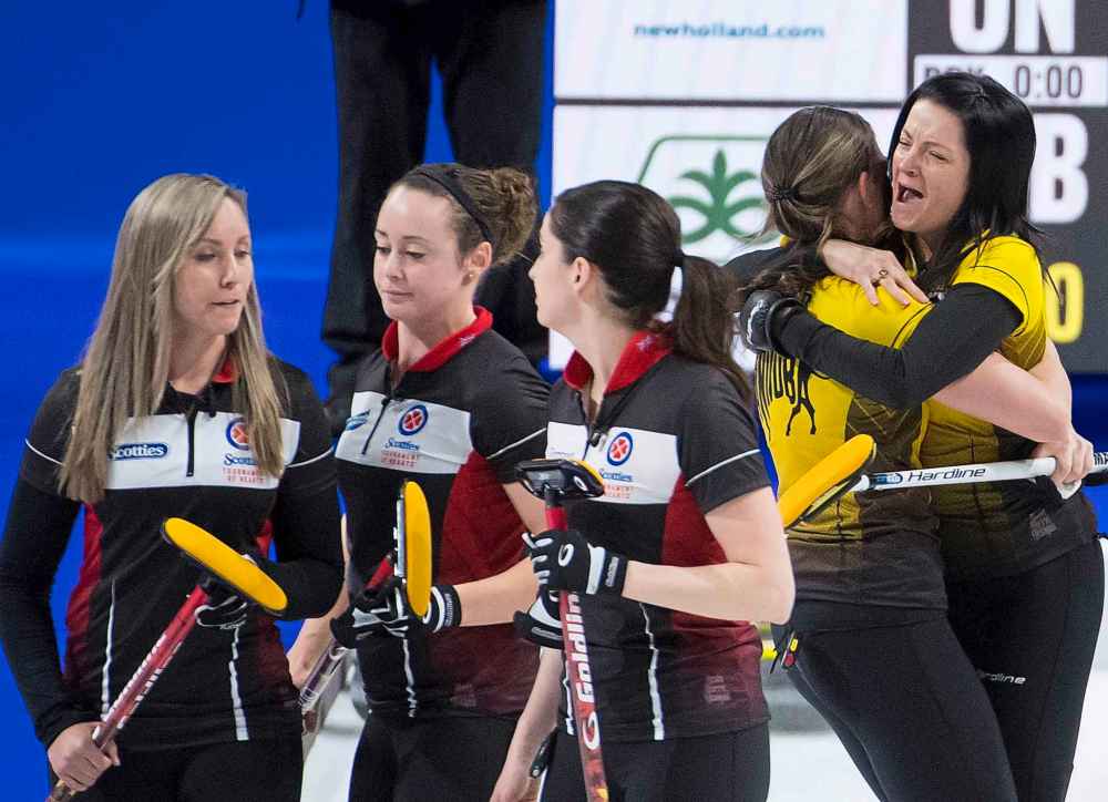 Team Manitoba lead, Briane Meilleur, back right, and skip Kerri Einarson celebrate after defeating Team Ontario, skip, Rachel Homan, left to right, second, Joanne Courtney and lead, Lisa Weagle to win the Scotties Tournament of Hearts. (Jonathan Hayward / The Canadian Press)