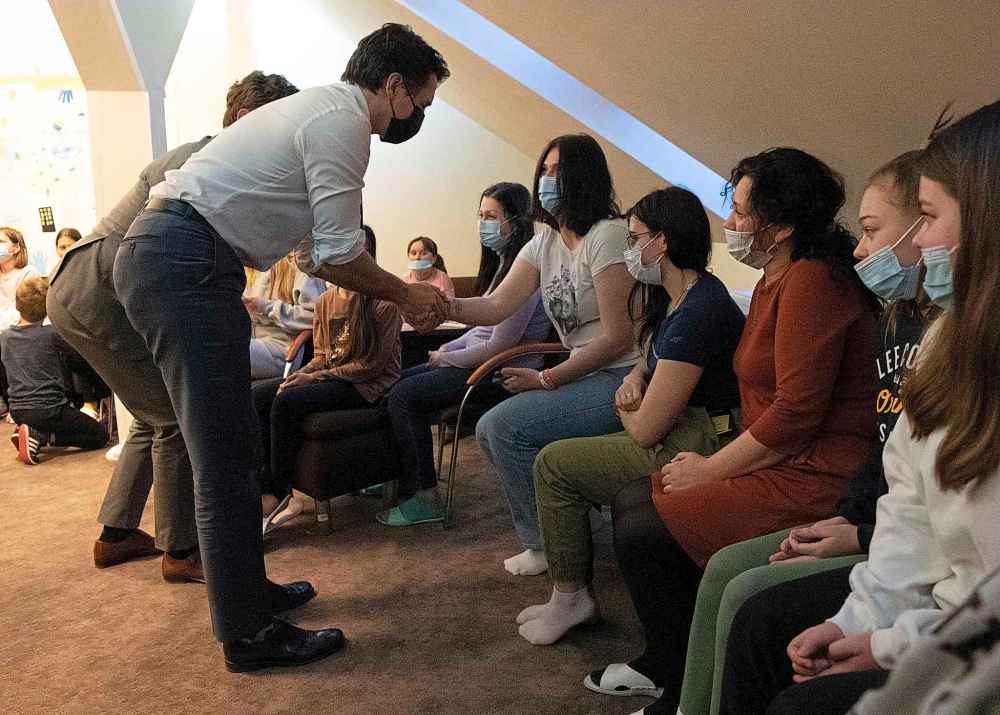 Canadian Prime Minister Justin Trudeau shakes hands with women as he visits with Ukrainian refugees in Warsaw, Poland, Thursday, March 10, 2022.  THE CANADIAN PRESS/Adrian Wyld