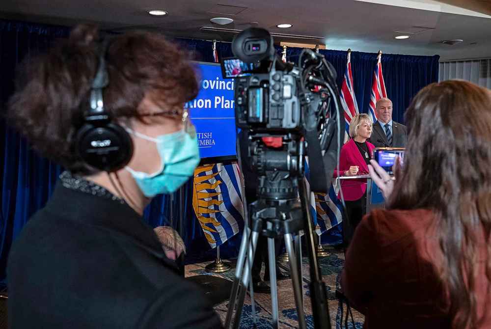 CP
A camera operator wears a protective mask as provincial health officer Dr. Bonnie Henry responds to questions with B.C. Premier John Horgan. (Darryl Dyck / The Canadian Press)