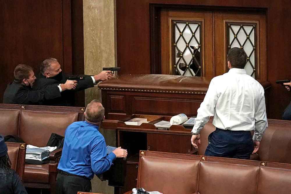 Police with guns drawn watch as protesters try to break into the House Chamber at the U.S. Capitol on Wednesday, Jan. 6, 2021, in Washington. (AP Photo/J. Scott Applewhite)