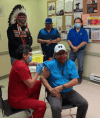 Cross Lake Coun. Mervin Garrick receives the first dose of the vaccine at the nursing station by Nurse Brenda Frogge on Thursday evening as Chief David Monias, Vice-Chief Ivan Monias and Coun. Donnie Mckay watch. (Facebook photo)