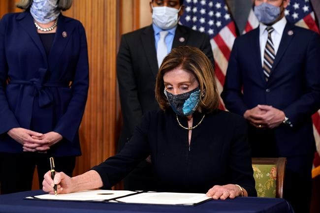 House Speaker Nancy Pelosi of Calif., signs the article of impeachment against President Donald Trump in an engrossment ceremony before transmission to the Senate for trial on Capitol Hill, in Washington, Wednesday, Jan. 13, 2021. (AP Photo/Alex Brandon)