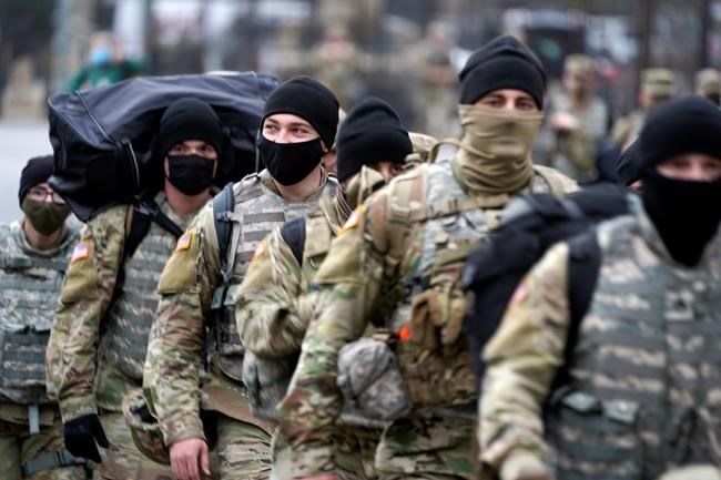 National Guard walk near the Capitol as security is increased ahead of the inauguration of President-elect Joe Biden and Vice President-elect Kamala Harris, Sunday, Jan. 17, 2021, in Washington. (AP Photo/Julio Cortez)